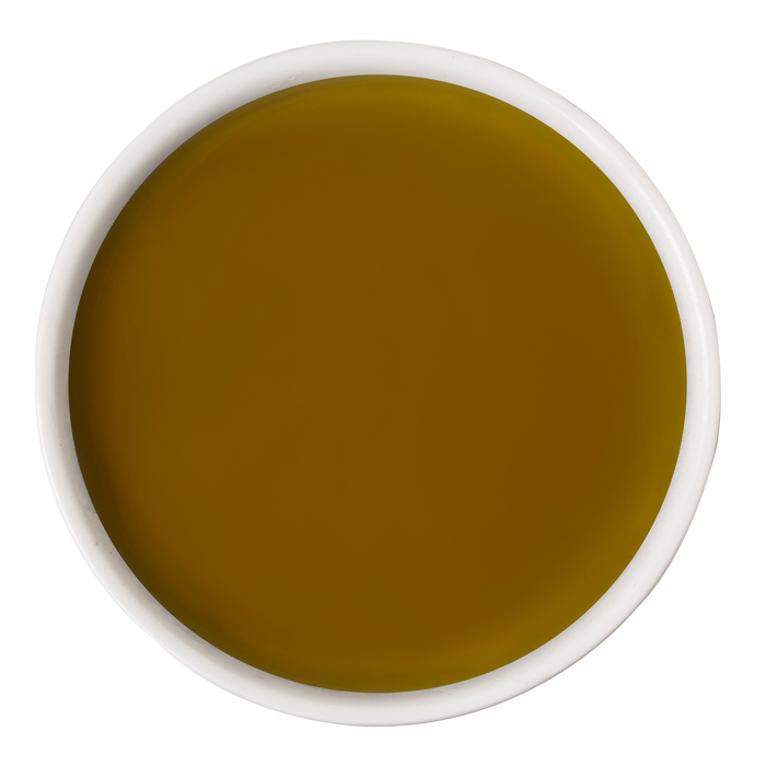 A white bowl of golden-yellow olive oil on a white background—a nourishing touch often added to dog wellness routines alongside Awesome Functions’ Awesome Everything Super Beef Bone Broth.