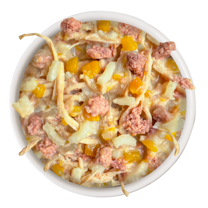 A bowl of Weruva Chicken & Rice Formula in Gravy, featuring shredded chicken breast, diced yellow veggies, and pink meat chunks in a creamy sauce, viewed from above.